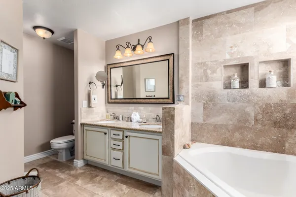 a bathroom with a tub sink toilet and mirror