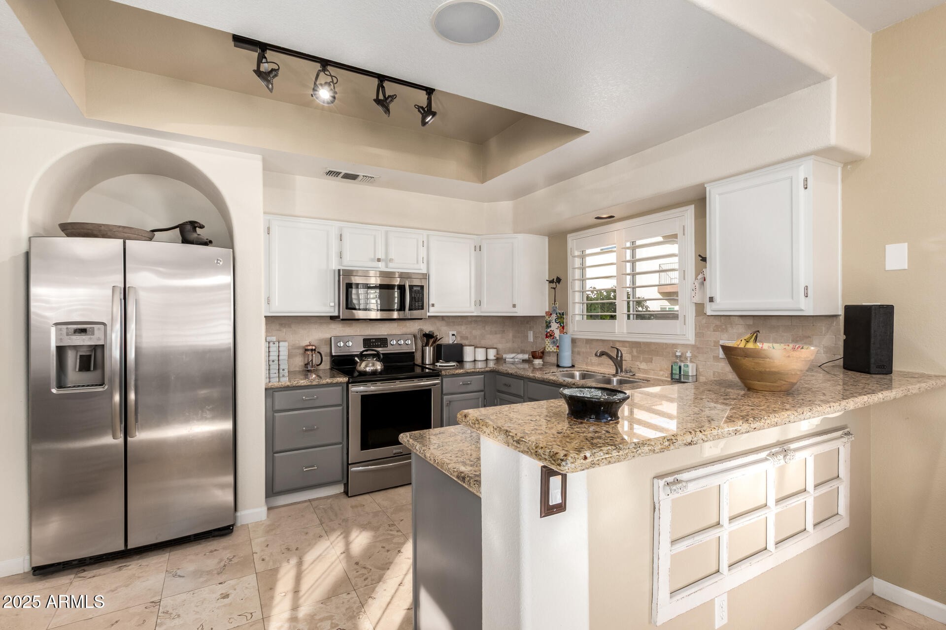8818 South 51st Street, Unit 1 Phoenix, AZ 85044 - Photo 7 of 26 a kitchen with stainless steel appliances granite countertop a stove a refrigerator a sink dishwasher and white cabinets next to a window
