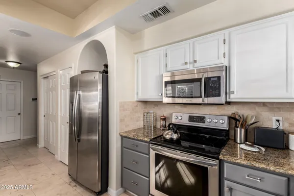 a kitchen with stainless steel appliances granite countertop a stove a refrigerator and a microwave
