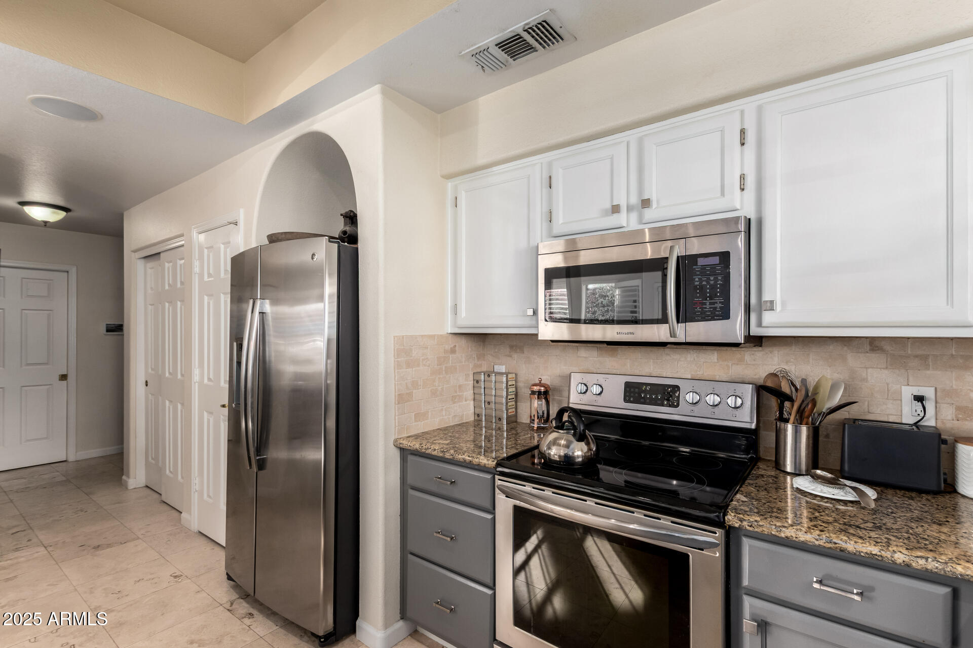 8818 South 51st Street, Unit 1 Phoenix, AZ 85044 - Photo 8 of 26 a kitchen with stainless steel appliances granite countertop a stove a refrigerator and a microwave