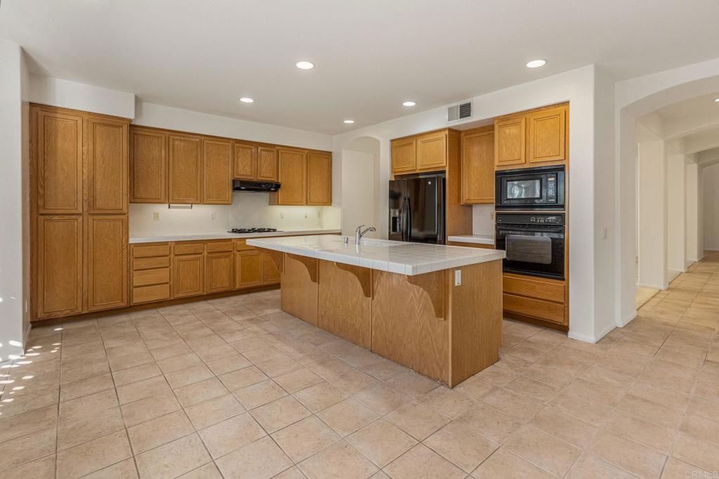 564 Echo Lane San Marcos, CA 92078 - Photo 11 of 27 a kitchen with stainless steel appliances granite countertop a refrigerator and a stove top oven