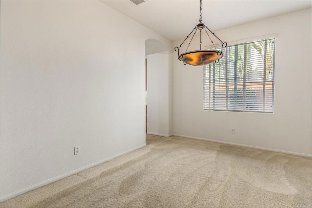 564 Echo Lane San Marcos, CA 92078 - Photo 7 of 27 an empty room with chandelier fan and windows
