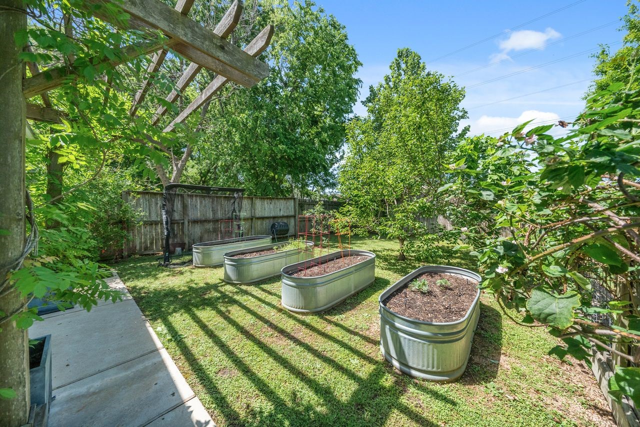 6510 Community Drive Houston, TX 77005 - Photo 8 of 37 This expansive backyard features lush landscaping, ample space for multiple raised bed gardens, and fruit trees.