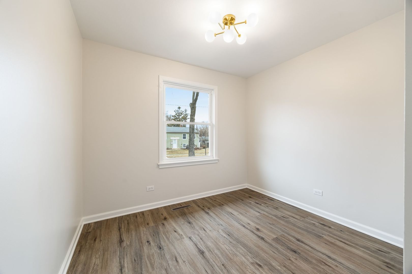 6791 Church Street Hanover Park, IL 60133 - Photo 15 of 24 an empty room with a wooden floor and a window