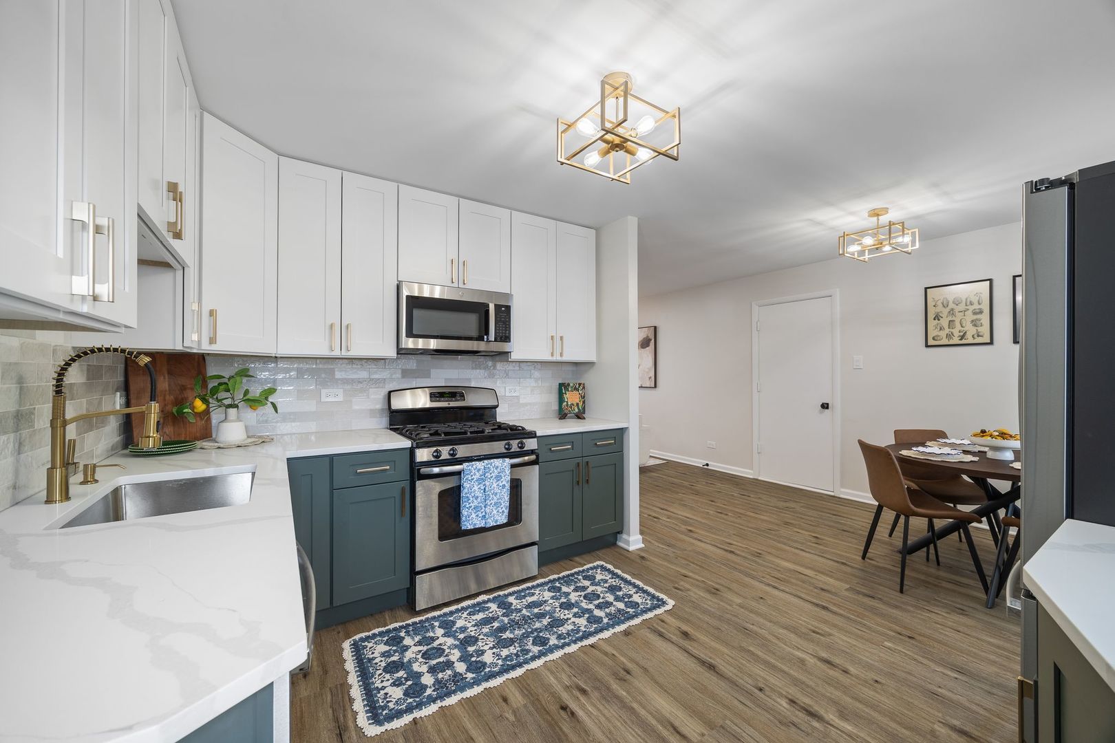6791 Church Street Hanover Park, IL 60133 - Photo 7 of 24 a kitchen with granite countertop a stove top oven a sink a dining table and chairs