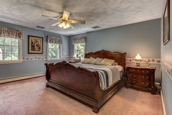 12 Ogunquit Road Wilmington, MA 01887 - Photo 17 of 27 a bedroom with a bed and a chandelier