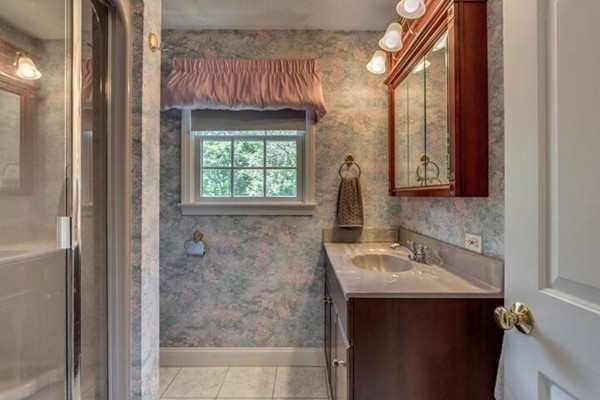 12 Ogunquit Road Wilmington, MA 01887 - Photo 18 of 27 a bathroom with a sink a mirror and a shower