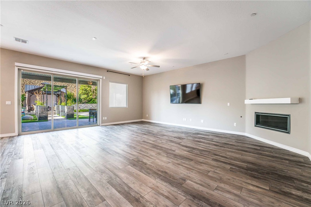 2787 Athens Ridge Drive Henderson, NV 89052 - Photo 3 of 31 A spacious living area with resilient wood flooring and a sleek corner fireplace.