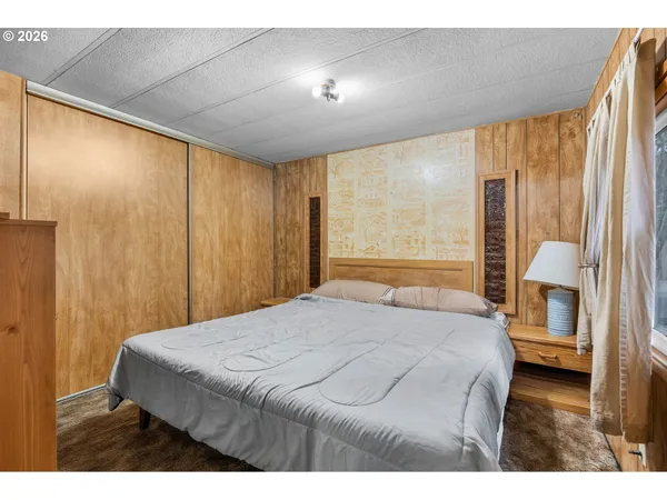 a bedroom with a bed and a large window