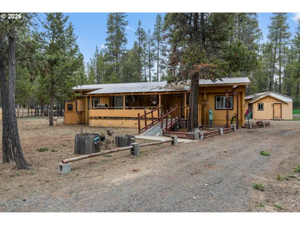 a view of a house with backyard and a tree