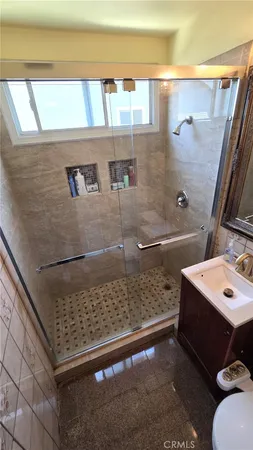 a bathroom with a sink a toilet and shower