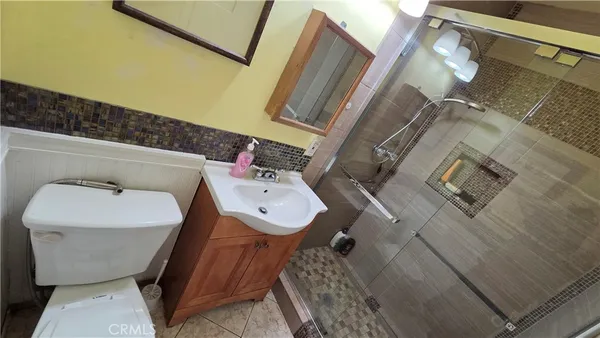 a bathroom with a sink and mirror with toilet