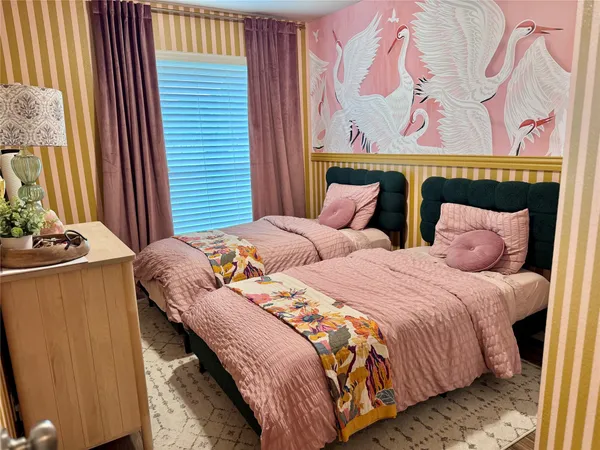 a bedroom with two beds and a painting on the wall