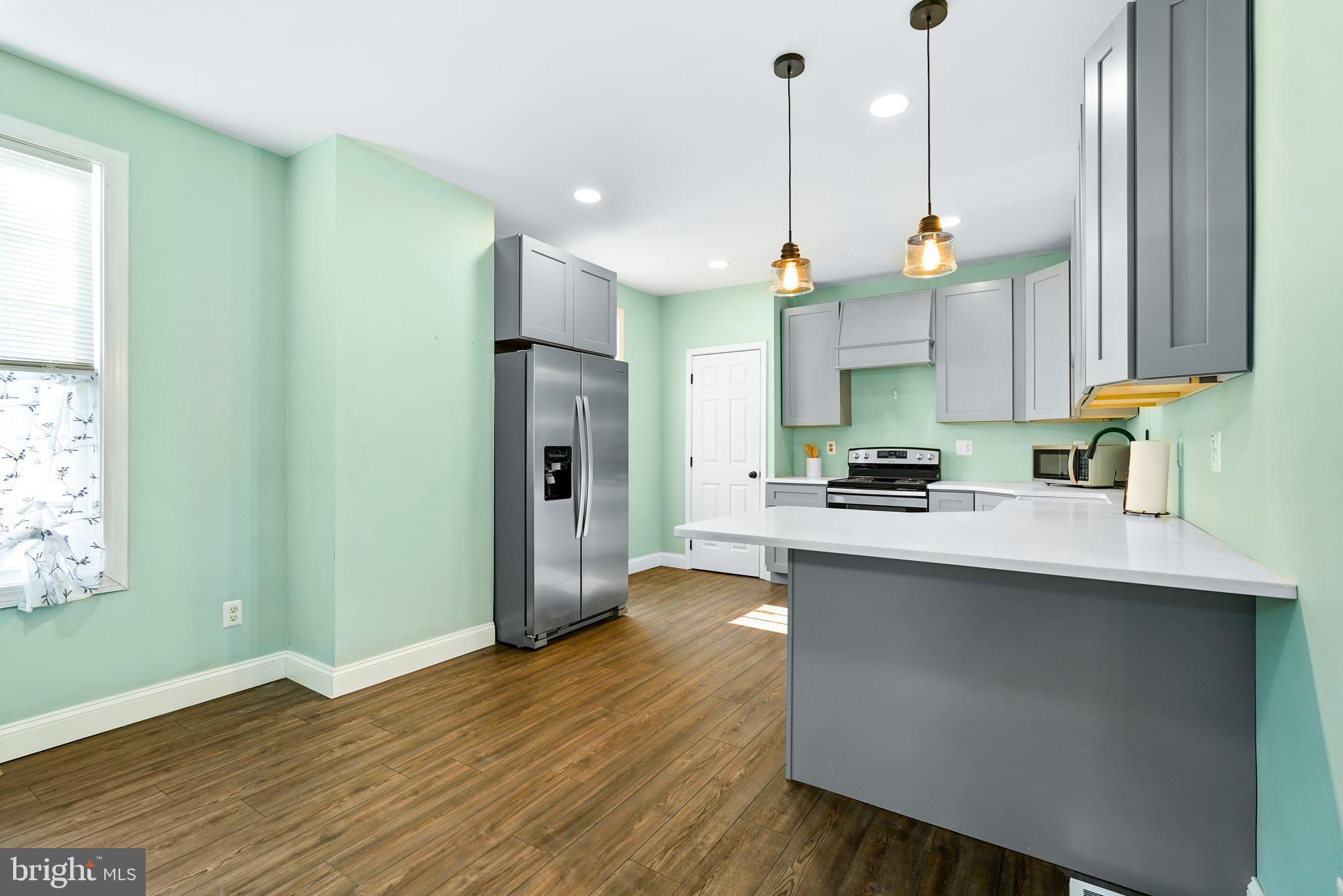 132 South Queen Street Rising Sun, MD 21911 - Photo 8 of 29 a kitchen with stainless steel appliances granite countertop a sink a stove a refrigerator and island with wooden floor