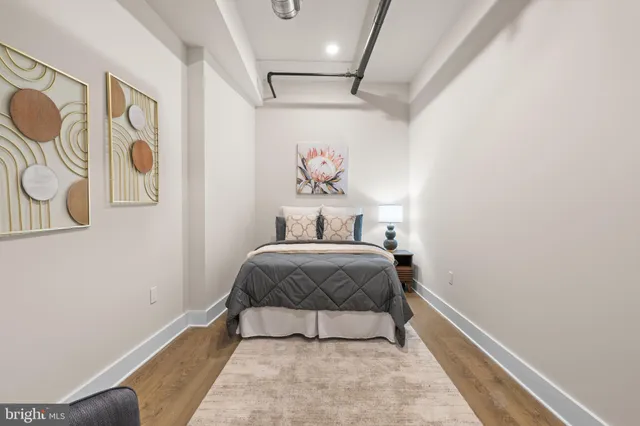 a bedroom with a bed couch and painting on the wall