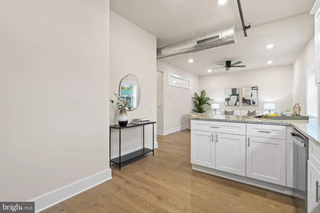 a kitchen with granite countertop white cabinets white stainless steel appliances with a sink and dishwasher
