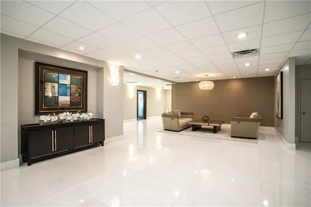 a living room with furniture potted plant and a large mirror