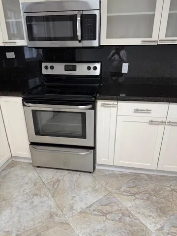 a kitchen with stainless steel appliances a stove and microwave