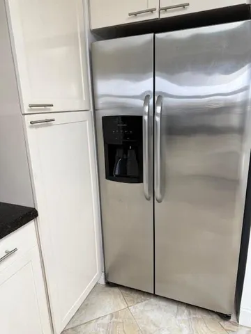 a close view of a refrigerator in kitchen and empty room
