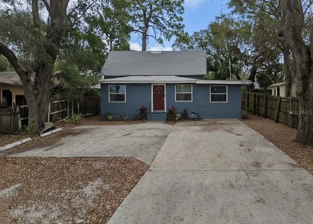 a view of a house with a yard and large tree