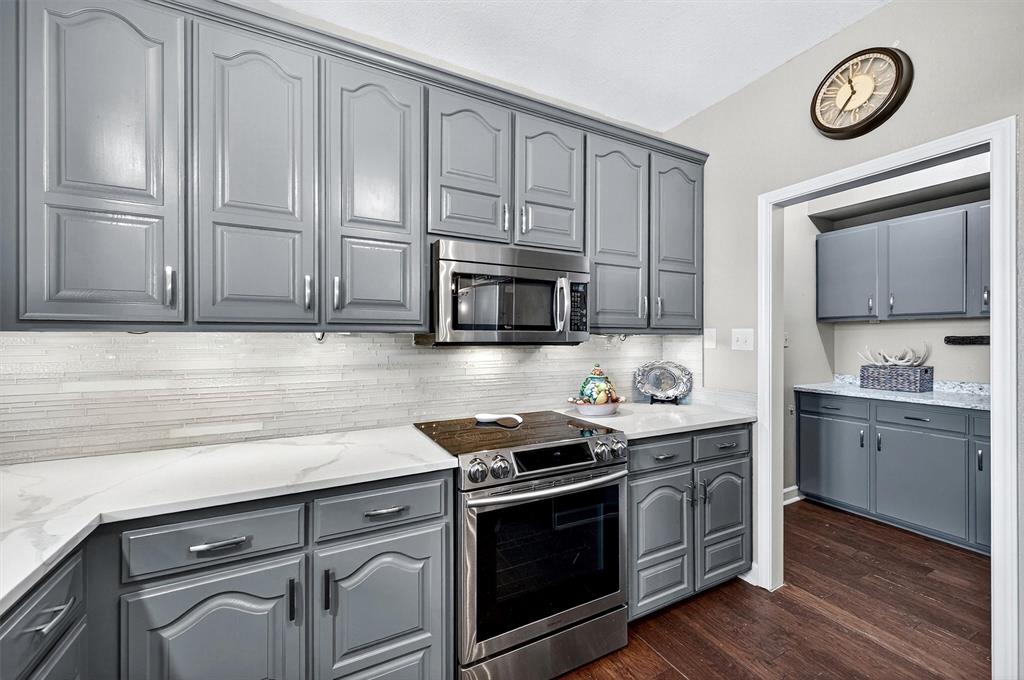 551 Massey Road Gunter, TX 75058 - Photo 11 of 40 a kitchen with granite countertop cabinets stainless steel appliances and a wooden floor