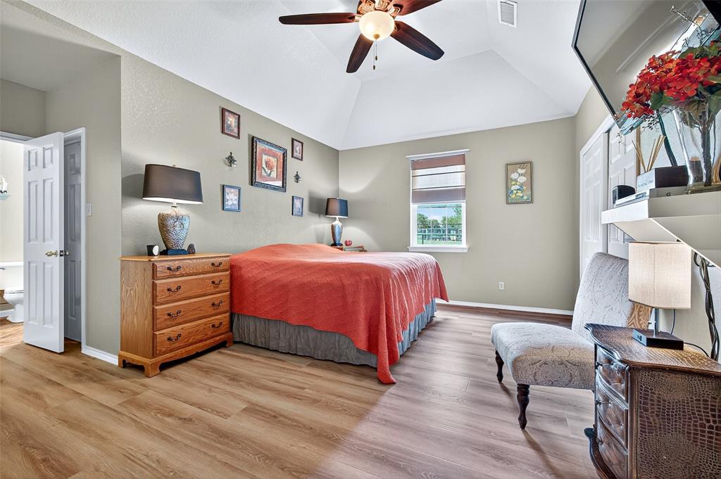 551 Massey Road Gunter, TX 75058 - Photo 14 of 40 a bedroom with a bed and a chandelier