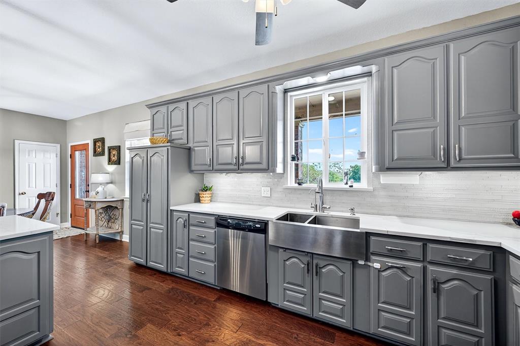 551 Massey Road Gunter, TX 75058 - Photo 10 of 40 a kitchen with stainless steel appliances granite countertop a sink cabinets and wooden floor