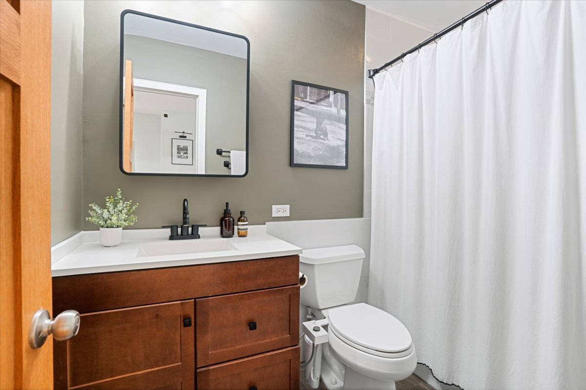 Undisclosed Address Chicago, IL 60613 - Photo 11 of 19 a bathroom with a toilet a sink and a mirror