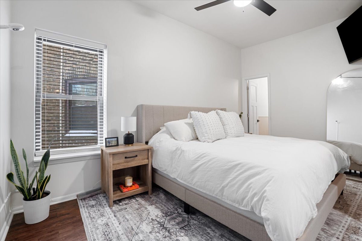 Undisclosed Address Chicago, IL 60613 - Photo 12 of 19 a spacious bedroom with a bed and a fireplace