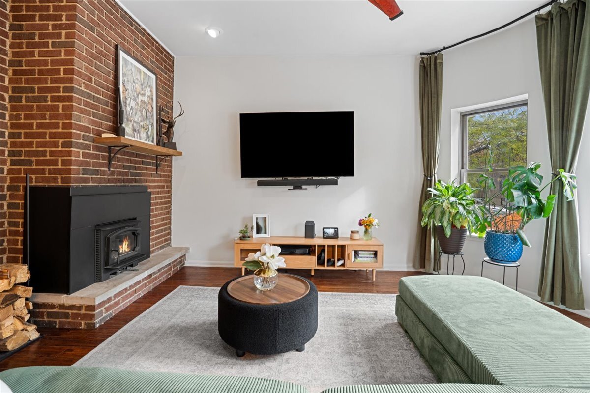 Undisclosed Address Chicago, IL 60613 - Photo 4 of 19 a living room with furniture a flat screen tv and a fireplace