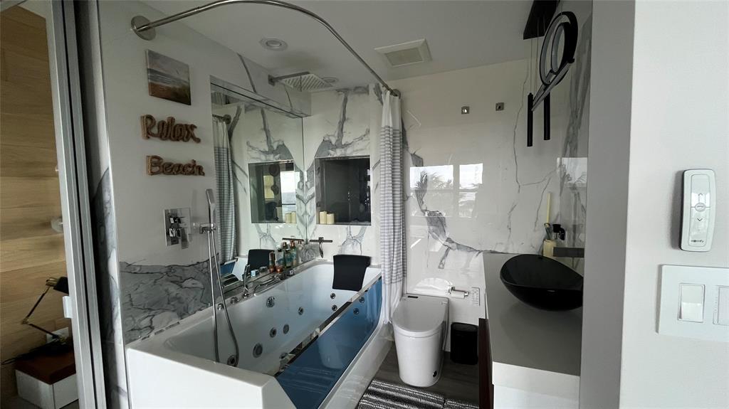 1041 Hillsboro Mile, Unit 3 Hillsboro Beach, FL 33062 - Photo 13 of 22 a bathroom with a tub and a mirror