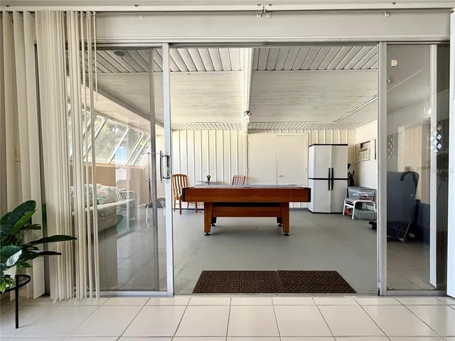 a living room with a table chairs and a window