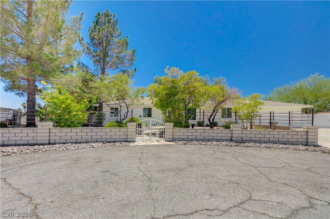 7631 Bermuda Road Las Vegas, NV 89123 - Photo 3 of 64 A private, gated entrance opens to a charming single-story residence surrounded by mature landscaping.