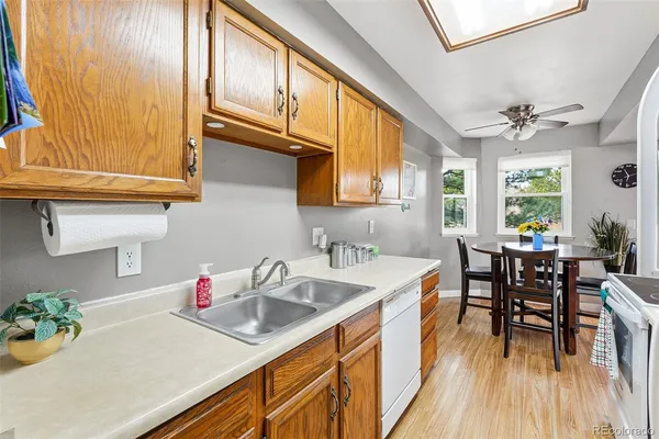 a kitchen with stainless steel appliances granite countertop a sink dishwasher and cabinets with wooden floor