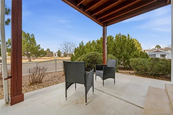 a patio with table and chairs and potted plants