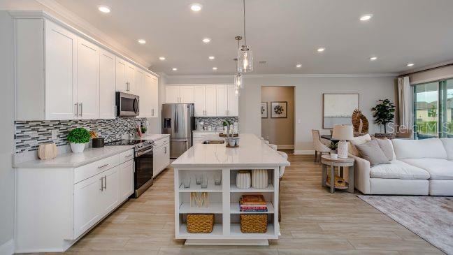 16492 Crane Road Weeki Wachee, FL 34614 - Photo 4 of 24 a living room with stainless steel appliances kitchen island granite countertop a stove a sink a refrigerator and white cabinets with wooden floor