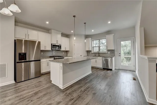 a kitchen with a refrigerator a sink and a stove top oven