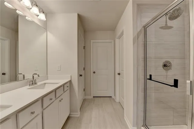 a spacious bathroom with a double vanity sink a mirror and shower