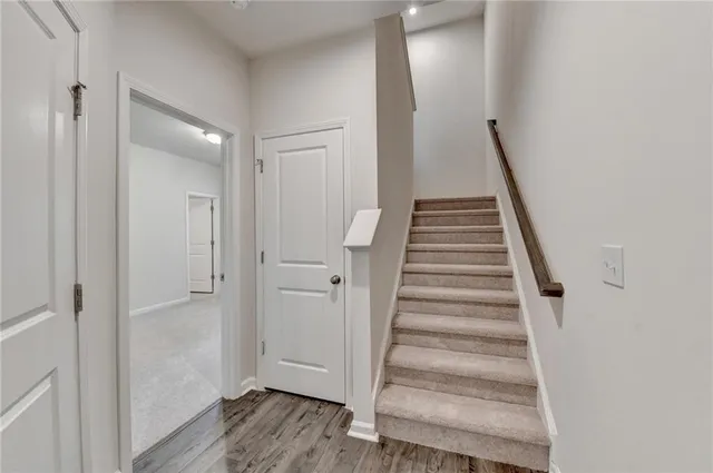 a view of a hallway with wooden floor and entryway