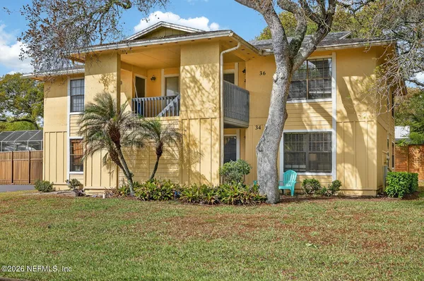 a view of a white house with a big yard and large trees