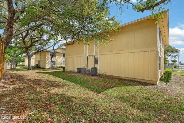 a view of a white house with large windows and a small yard