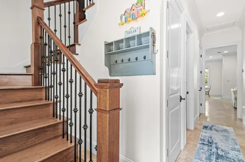a view of a hallway with wooden floor and staircase