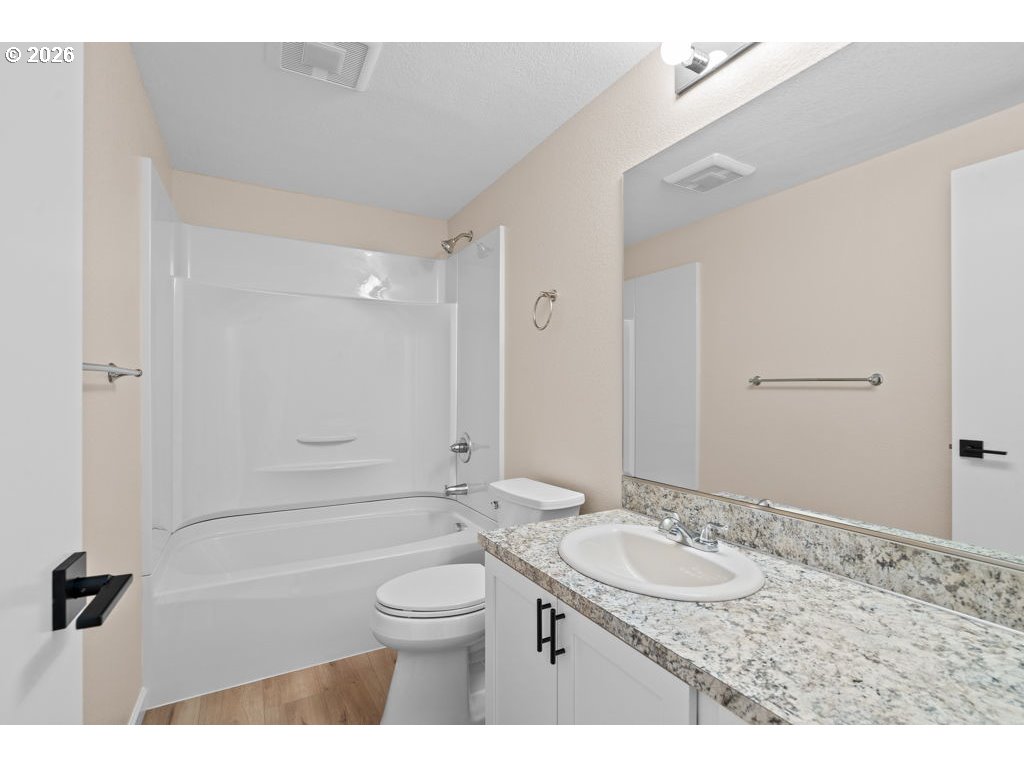 11201 Northwest 3rd Avenue Vancouver, WA 98685 - Photo 14 of 21 a bathroom with a granite countertop sink a toilet a mirror and shower