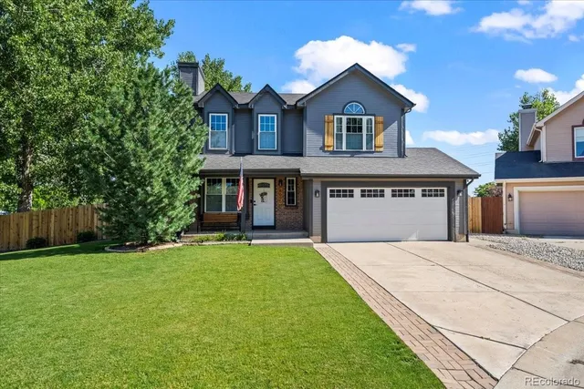 a front view of a house with yard and green space