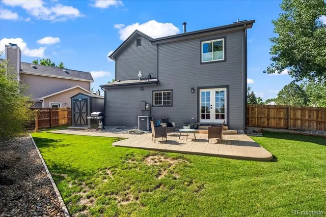a view of a house with backyard and sitting area