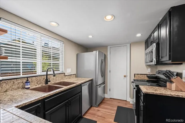 a kitchen with stainless steel appliances granite countertop a sink stove and refrigerator