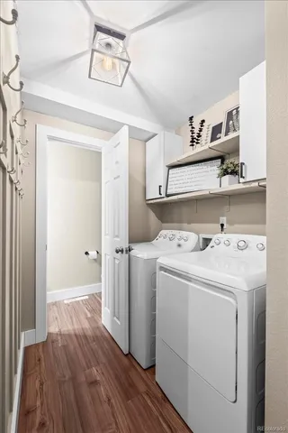 a view of washer and dryer with wooden cabinets