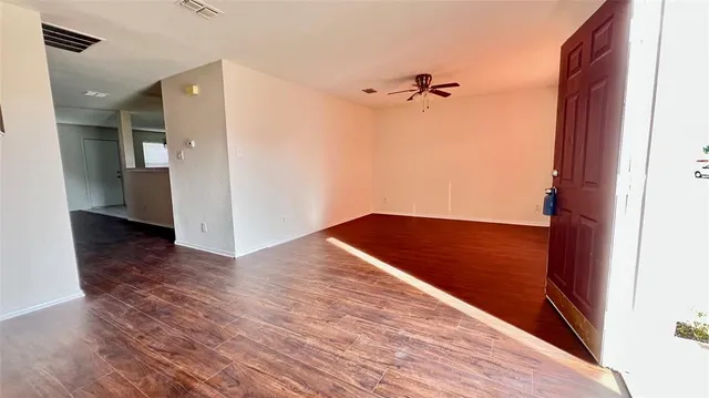 a view of empty room with wooden floor
