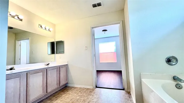 a bathroom with a tub shower and sink