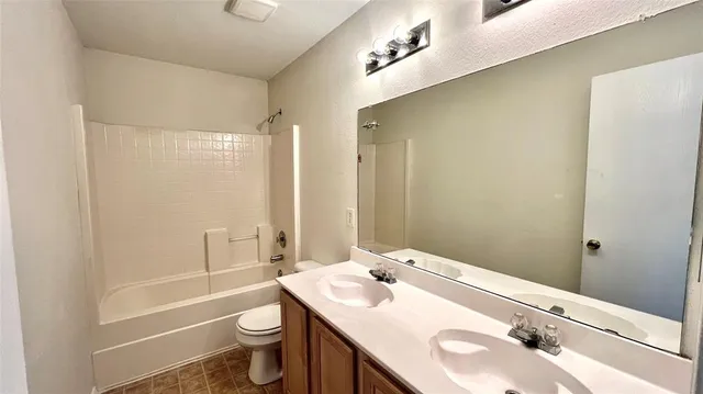 an empty room with wooden floor and a ceiling fan